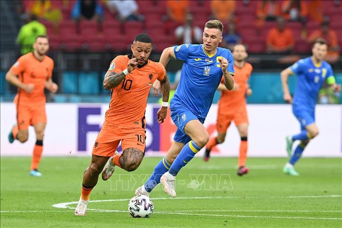 Trong ảnh: Tiền đạo Memphis Depay (trái) của Hà Lan đi bóng đẳng cấp, vượt qua hàng phòng ngự đối phương trước khi tung cú dứt điểm đi đúng tầm bắt của thủ môn Ukraina trong trận đấu vòng chung kết EURO 2020 trên sân ở Amsterdam, ngày 13/6/2021. Ảnh: AFP/TTXVN