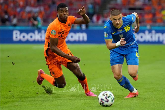 Trong ảnh: Hậu vệ Hà Lan Denzel Dumfries (trái) tranh bóng với hậu vệ Vitaliy Mykolenko của Ukraina trong trận đấu vòng chung kết EURO 2020 trên sân ở Amsterdam, ngày 13/6/2021. Ảnh: AFP/TTXVN