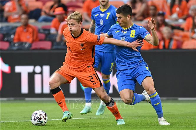 Trong ảnh: Tiền vệ Hà Lan Frenkie de Jong (trái) nỗ lực đi bóng qua người tiền vệ Ukraine Ruslan Malinovskyi trong trận đấu vòng chung kết EURO 2020 trên sân ở Amsterdam, ngày 13/6/2021. Ảnh: AFP/TTXVN