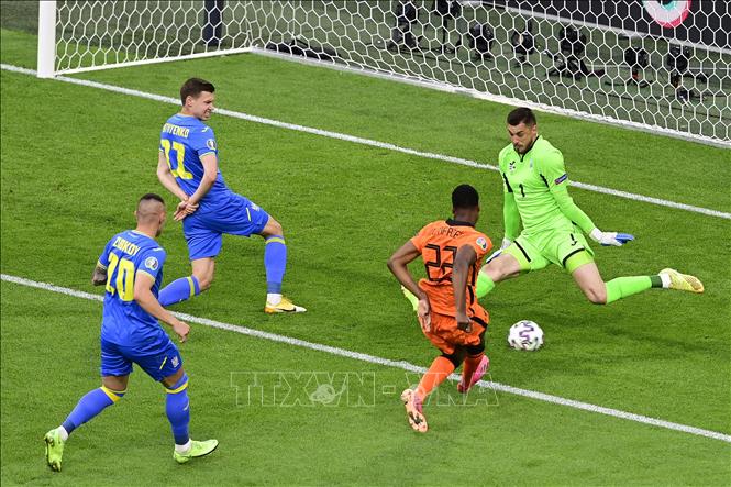 Trong ảnh: Thủ môn Ukraine Georgiy Bushchan (phải) cứu nguy một bàn thua cho đội nhà trước cú sút của hậu vệ Hà Lan Denzel Dumfries (thứ 2, phải) trong trận đấu vòng chung kết EURO 2020 trên sân ở Amsterdam, ngày 13/6/2021. Ảnh: AFP/TTXVN