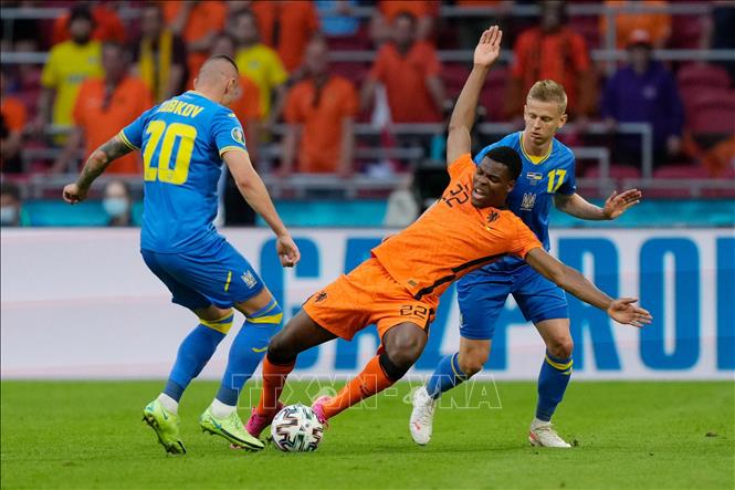Trong ảnh: Pha tranh bóng quyết liệt giữa hậu vệ Hà Lan Denzel Dumfries (giữa) và các cầu thủ Ukraine trong trận đấu vòng chung kết EURO 2020 trên sân ở Amsterdam, ngày 13/6/2021. Ảnh: AFP/TTXVN