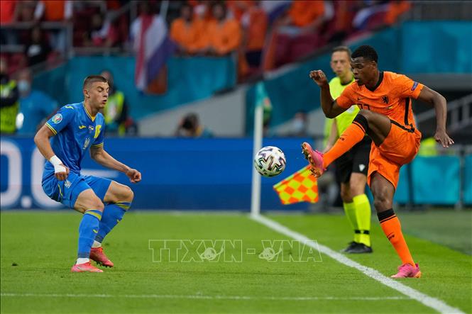 Trong ảnh: Hậu vệ Hà Lan Denzel Dumfries (phải) nỗ lực kiểm soát bóng trước hậu vệ Vitaliy Mykolenko của Ukraine trong trận đấu vòng chung kết EURO 2020 trên sân ở Amsterdam, ngày 13/6/2021. Ảnh: AFP/TTXVN