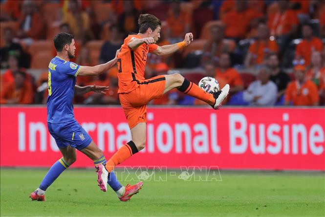 Trong ảnh: Tiền vệ Hà Lan Marten de Roon (phải) nỗ lực khống chế bóng khi bị cầu thủ Ukraine đeo bám trong trận đấu tại vòng chung kết EURO 2020 ở Amsterdam, ngày 13/6/2021. Ảnh: THX/TTXVN