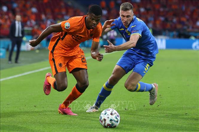Trong ảnh: Hậu vệ Hà Lan Denzel Dumfries (trái) nỗ lực đi bóng khi bị tiền vệ Ukraine Serhiy Sydorchuk đeo bám trong trận đấu tại vòng chung kết EURO 2020 ở Amsterdam, ngày 13/6/2021. Ảnh: THX/TTXVN