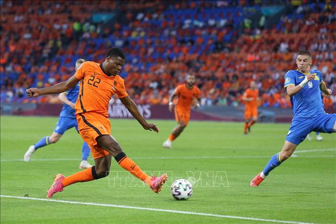 Trong ảnh: Hậu vệ Hà Lan Denzel Dumfries (trái) tung cú sút bóng về phía cầu môn tuyển Ukraine trong trận đấu tại vòng chung kết EURO 2020 ở Amsterdam, ngày 13/6/2021. Ảnh: THX/TTXVN