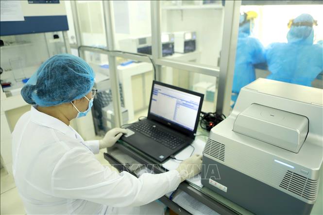 Trong ảnh: Cài đặt chương trình chạy máy Real time RT-PCR (một chương trình trong công tác xét nghiệm khẳng định virus SARS-CoV-2). Ảnh: Hoàng Hùng -TTXVN