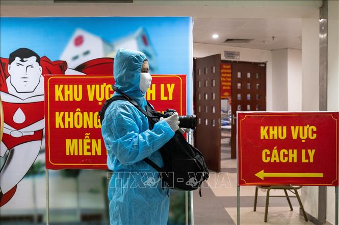 Phóng viên Minh Quyết, Ban Biên tập ảnh TTXVN tác nghiệp trong khu cách ly phòng COVID-19 của Viện Huyết học Truyền máu TƯ. Ảnh: TTXVN