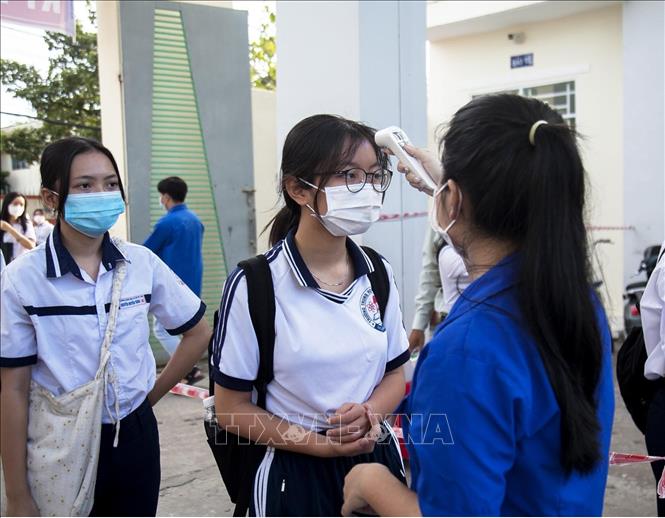 Trong ảnh: Đo thân nhiệt cho thí sinh tại điểm thi Trường THPT Nguyễn Trung Trực, thành phố Rạch Giá. Ảnh: Hồng Đạt - TTXVN