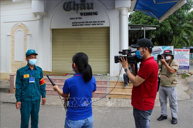 Trong ảnh: Phóng viên Truyền hình Thông tấn xã Việt Nam tại Đà Nẵng đang tác nghiệp tại khu vực bị phong tỏa ở Đà Nẵng. Ảnh: Trần Lê Lâm - TTXVN