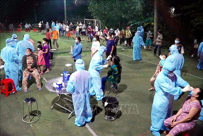 Photo: Medical workers take samples for rapid COVID-19 testing for residents in An Lac Ward, Binh Tan District in Ho Chi Minh City. VNA Photo: Thanh Vũ