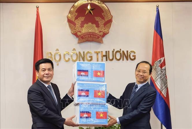 Trong ảnh: Bộ trưởng Bộ Công Thương Nguyễn Hồng Diên trao tượng trưng 20 ngàn khẩu trang phòng, chống dịch COVID-19 cho Đại sứ Campuchia tại Việt Nam Chay Navuth (6/5/2021). Ảnh: Trần Việt – TTXVN