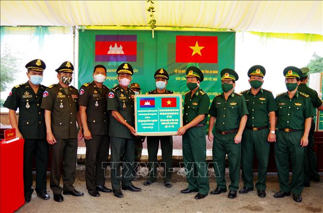 Trong ảnh: Đại tá Phạm Văn Phong, Chính ủy Bộ đội Biên phòng tỉnh An Giang (thứ 4 phải qua) trao biểu trưng tặng tiền mặt, vật tư y tế phòng, chống dịch COVID-19 cho lực lượng Tiểu khu Quân sự tỉnh Takeo, Vương quốc Campuchia. Ảnh: Công Mạo-TTXVN