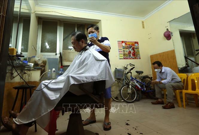 Photo: The owner of a hair salon in Pham Dinh Ho ward, Hai Ba Trung district, is busy on the reopening day. VNA Photo