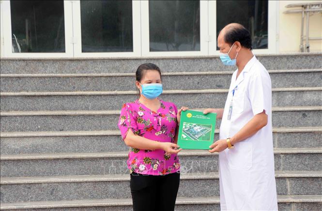 Trong ảnh: Trao Quyết định khỏi bệnh và xuất viện cho bệnh nhân 4367, trở về huyện Mai Sơn, tỉnh Sơn La tiếp tục cách ly 14 ngày theo quy định. Ảnh: Quang Quyết-TTXVN