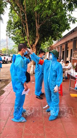 Trong ảnh: Cán bộ y tế Hà Giang đo thân nhiệt các công dân từ tâm dịch Bắc Giang về địa phương. Ảnh: TTXVN phát