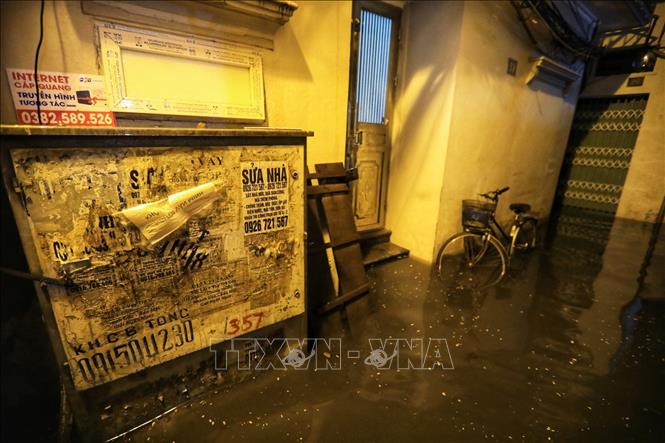 Trong ảnh: Cơn mưa lớn tối 22/6 khiến ngõ 90, phố Đội Cấn (Hà Nội) ngập sâu trong nước. Ảnh: Thành Đạt - TTXVN