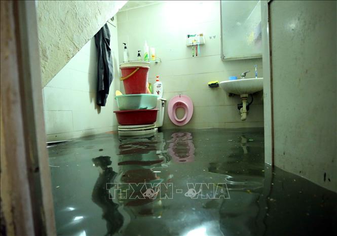 Trong ảnh: Cơn mưa lớn làm ảnh hưởng đến sinh hoạt của một số hộ dân sống tại ngõ 90, phố Đội Cấn (Hà Nội). Ảnh: Phạm Kiên - TTXVN