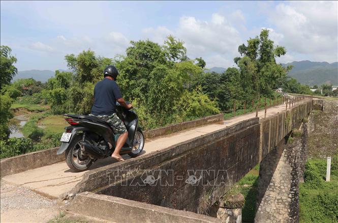 Trong ảnh: Để qua được cầu, người đàn ông này phải hạ chân lấy thăng bằng, mất khá nhiều thời gian để qua cầu. Ảnh: Xuân Tiến - TTXVN