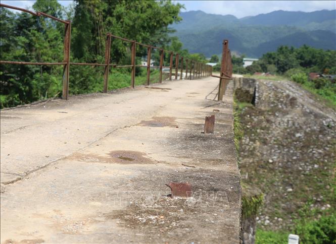 Trong ảnh: Hệ thống lan can một bên cầu bị gãy rụng, còn trơ chân cọc trên cầu. Ảnh: Xuân Tiến – TTXVN 
