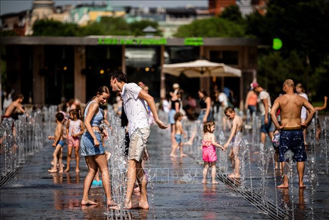 Trong ảnh: Người dân giải nhiệt tại đài phun nước trong thời tiết nắng nóng ở Moskva, Nga, ngày 21/6/2021. Ảnh: AFP/TTXVN