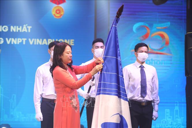 Trong ảnh: Phó Chủ tịch nước Võ Thị Ánh Xuân gắn Huân chương Lao động hạng Nhất lên cờ truyền thống của VNPT VinaPhone. Ảnh: Minh Quyết - TTXVN