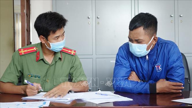 Đối tượng Đời (phải) thừa nhận với cơ quan Công an rằng thông tin trên là do mình nghĩ ra, thu âm bằng điện thoại rồi chia sẽ lên mạng xã hội Zalo. Ảnh: TTXVN phát