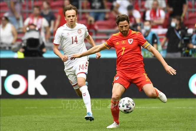Trong ảnh: Tiền vệ Xứ Wales Joe Allen (phải) nỗ lực kiểm soát bóng trước tiền đạo Đan Mạch Mikkel Damsgaard trong trận đấu tại vòng 16 đội, Vòng chung kết EURO 2020 trên sân vận động Johan Cruyff Arena ở thủ đô Amsterdam, Hà Lan ngày 26/6/2021. Ảnh: AFP/TTXVN