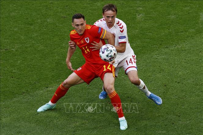 Trong ảnh: Hậu vệ Xứ Wales Connor Roberts (trái) tranh bóng với tiền đạo Đan Mạch Mikkel Damsgaard trong trận đấu tại vòng 16 đội, Vòng chung kết EURO 2020 trên sân vận động Johan Cruyff Arena ở thủ đô Amsterdam, Hà Lan ngày 26/6/2021. Ảnh: AFP/TTXVN