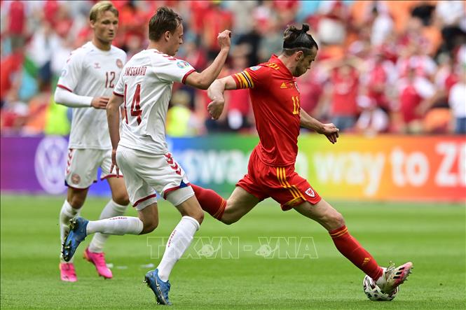 Trong ảnh: Tiền đạo Xứ Wales Gareth Bale (phải) đi bóng trước các cầu thủ Đan Mạch trong trận đấu tại vòng 16 đội, Vòng chung kết EURO 2020 trên sân vận động Johan Cruyff Arena ở thủ đô Amsterdam, Hà Lan ngày 26/6/2021. Ảnh: AFP/TTXVN