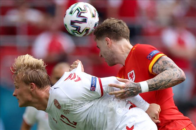 Trong ảnh: Pha tranh bóng bổng giữa tiền đạo Đan Mạch Kasper Dolberg (trái) và hậu vệ Xứ Wales Joe Rodon trong trận đấu tại vòng 16 đội, Vòng chung kết EURO 2020 trên sân vận động Johan Cruyff Arena ở thủ đô Amsterdam, Hà Lan ngày 26/6/2021. Ảnh: AFP/TTXVN