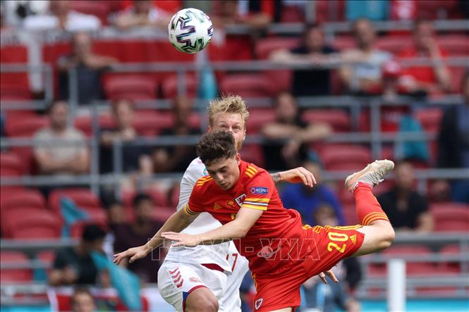 Trong ảnh: Pha tranh bóng bổng giữa hậu vệ Đan Mạch Simon Kjaer (trái) và tiền vệ Xứ Wales Daniel James trong trận đấu tại vòng 16 đội, Vòng chung kết EURO 2020 trên sân vận động Johan Cruyff Arena ở thủ đô Amsterdam, Hà Lan ngày 26/6/2021. Ảnh: AFP/TTXVN