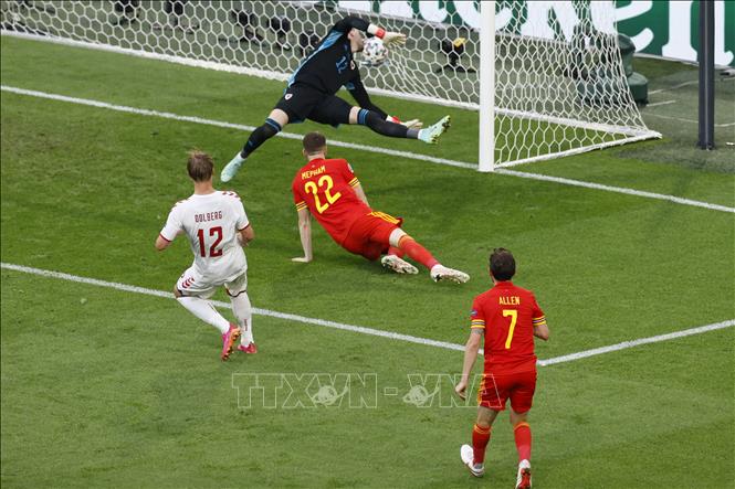 Trong ảnh: Tiền đạo Đan Mạch Kasper Dolberg (trái) sút bóng vào lưới Xứ Wales, nâng tỷ số lên 2-0 cho đội nhà trong trận đấu tại vòng 16 đội, Vòng chung kết EURO 2020 trên sân vận động Johan Cruyff Arena ở thủ đô Amsterdam, Hà Lan ngày 26/6/2021. Ảnh: AFP/TTXVN