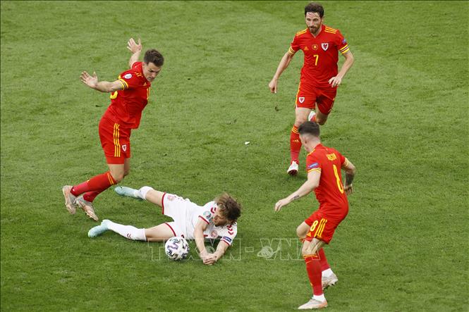 Trong ảnh: Tiền vệ Đan Mạch Mathias Jensen (giữa) nỗ lực tranh bóng trong vòng vây các cầu thủ Xứ Wales trong trận đấu tại vòng 16 đội, Vòng chung kết EURO 2020 trên sân vận động Johan Cruyff Arena ở thủ đô Amsterdam, Hà Lan ngày 26/6/2021. Ảnh: AFP/TTXVN