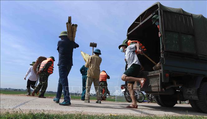 Trong ảnh: Tình huống giả định của buổi diễn tập: lực lượng chức năng được huy động để xử lý mạch đùn, mạch sủi số 1 tại chân đê địa phận thôn Chằm, xã Hoàng Đan, huyện Tam Dương, đe dọa vỡ đê tả Phó Đáy. Ảnh: Hoàng Hùng - TTXVN