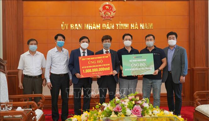 Trong ảnh: Tiếp nhận ủng hộ 1 tỷ đồng từ Công ty TNHH Anam Electronics Việt Nam. Ảnh: Nguyễn Chinh - TTXVN