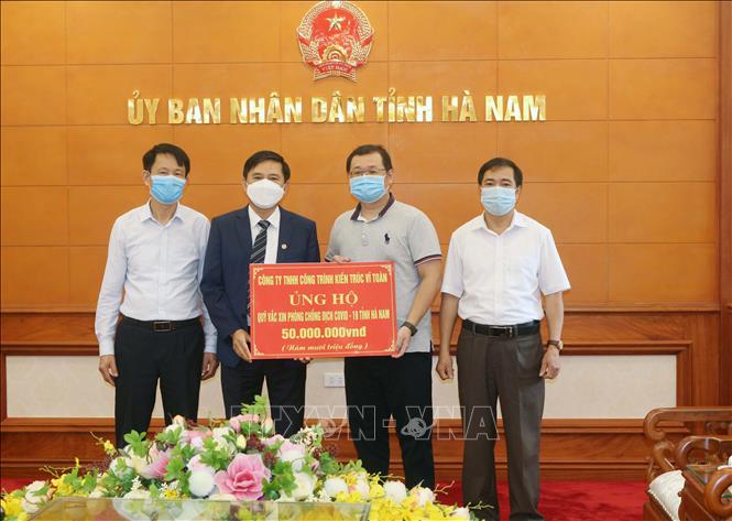 Trong ảnh: Tiếp nhận ủng hộ 50 triệu đồng từ Công ty TNHH công trình kiến trúc Vĩ Toàn. Ảnh: Nguyễn Chinh - TTXVN