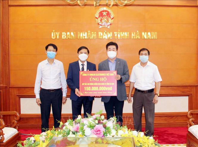 Trong ảnh: Tiếp nhận ủng hộ 150 triệu đồng từ Công ty Sunlin Electronics Việt Nam. Ảnh: Nguyễn Chinh - TTXVN
