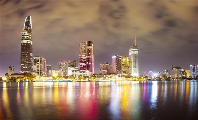 Những tòa nhà cao tầng in bóng lung linh xuống sông Sài Gòn trong đêm. Ảnh: Trọng Đạt - TTXVN