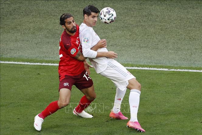 Trong ảnh: Pha tranh bóng quyết liệt giữa tiền đạo Alvaro Morata (phải ) đội Tây Ban Nha và hậu vệ  Ricardo Rodrigue, đội Thụy Sĩ trong trận đấu ở vòng tứ kết Giải vô địch bóng đá châu Âu (EURO) 2020, trên sân vận động Saint Petersburg, Nga, ngày 2/7/2021. Ảnh: AFP/TTXVN