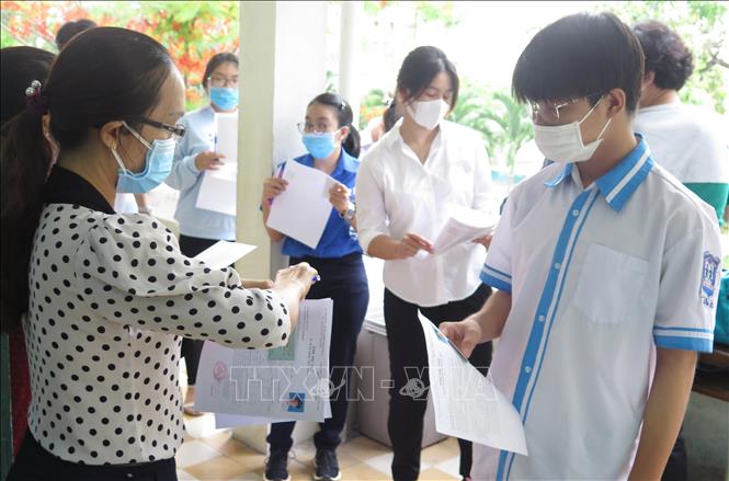 Trong ảnh: Giám thị phòng thi điểm thi trường THPT Nguyễn Văn Trỗi, thành phố Nha Trang kiểm tra thẻ dự thi của thí sinh trước khi vào phòng thi ở buổi thi môn Ngữ văn sáng 7/7. Ảnh: Phan Sáu-TTXVN                             