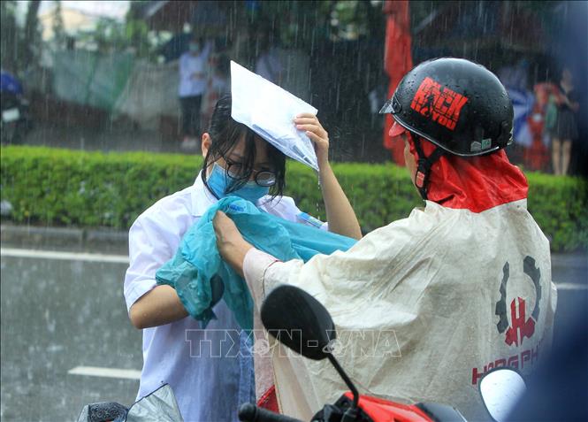Trong ảnh: Các thí sinh hoàn thành các môn thi, ra về dưới cơn mưa lớn do ảnh hưởng của áp thấp nhiệt đới. Ảnh: An Đăng - TTXVN
