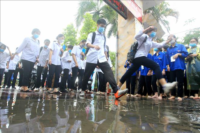Trong ảnh: Cơn mưa lớn kéo dài, một số điểm thi bị ngập, ảnh hưởng đến việc di chuyển của các thí sinh. Ảnh: An Đăng - TTXVN