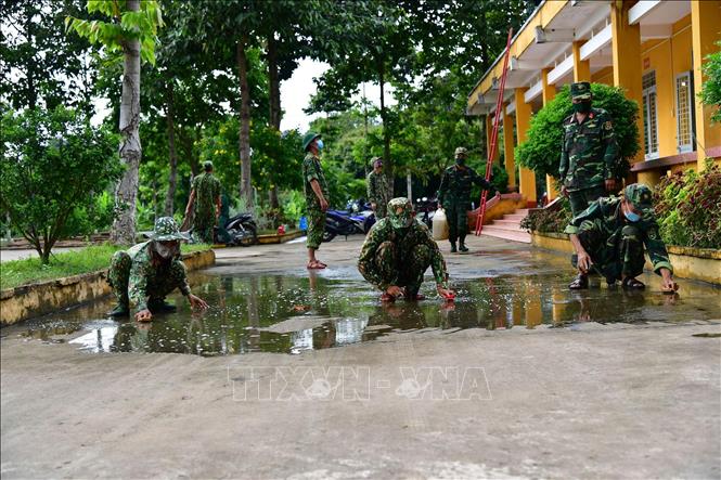 Cán bộ, chiến sĩ vệ sinh khuôn viên bên ngoài Bệnh viện dã chiến số 6. Ảnh: Hữu Chí – TTXVN