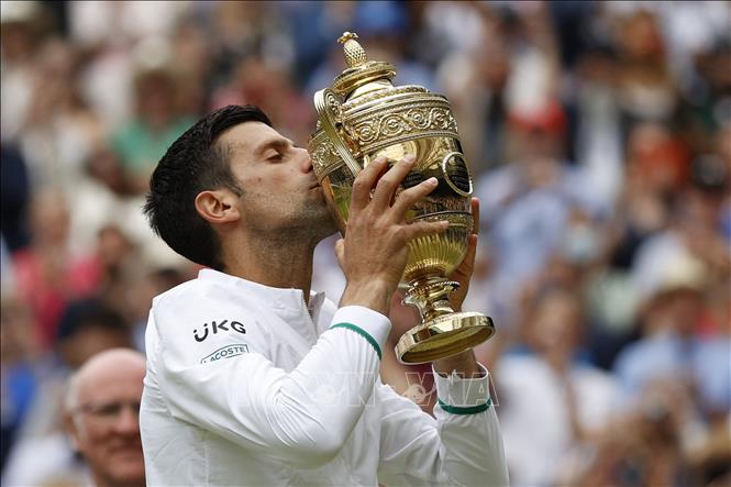 Trong ảnh: Novak Djokovic đoạt cup vô địch Wimbledon 2021 trong trận chung kết đơn nam gặp tay vợt Italy Matteo Berrettini ở London (Anh) ngày 11/7/2021. Ảnh: AFP/TTXVN