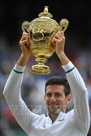 Trong ảnh: Novak Djokovic (Serbia) đoạt cup vô địch Wimbledon 2021 trong trận chung kết đơn nam gặp tay vợt Italy Matteo Berrettini ở London (Anh) ngày 11/7/2021. Ảnh: AFP/TTXVN