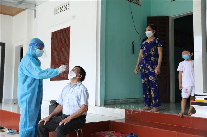 Trong ảnh: Nhân viên y tế xã Hoà Thạch đến lấy mẫu người trở về từ Thành phố Hồ Chí Minh tại thôn Vinh Quang, xã Hoà Thạch. Ảnh: Minh Quyết - TTXVN