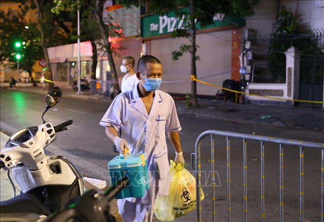 Trong ảnh: Đến 22h, lực lượng y tế rời khỏi khu vực phong tỏa sau khi đã lấy mẫu, phun khử khuẩn. Ảnh: Hoàng Hiếu - TTXVN 