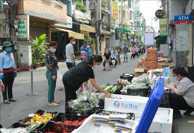 Trong ảnh: Người dân mua hàng hóa thiết yếu tại một “Phiên chợ lưu động” được tổ chức tại khu phố 3, phường 2, Quận 3, Thành phố Hồ Chí Minh. Ảnh: Quang Châu - TTXVN

