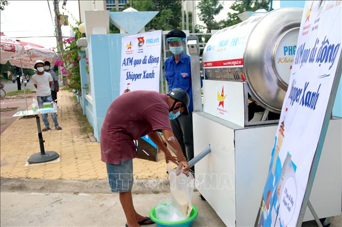 Người dân lấy gạo tại “ATM gạo di động - Shipper xanh” đặt tại Tỉnh đoàn Bình Thuận. Ảnh: Nguyễn Thanh - TTXVN