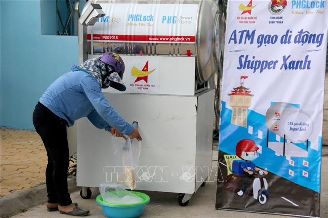 Người dân lấy gạo tại “ATM gạo di động - Shipper xanh” đặt tại Tỉnh đoàn Bình Thuận. Ảnh: Nguyễn Thanh - TTXVN